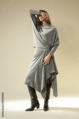 Studio Portrait of Model in Grey Knitted Monochrome Outfit with Asymmetrical Midi Skirt