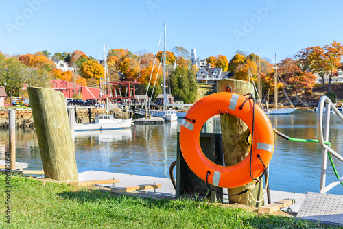 фотографія Close up of a lifebuoy hanging from a wooden mooring post along a harbour on a s
