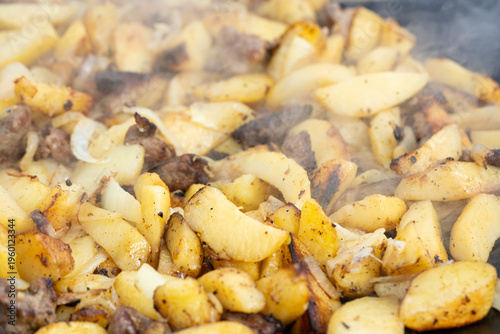 Cooking potatoes on an open fire, fried potatoes. Appetizing natural food