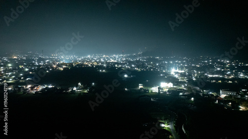 Tableau sur toile Aerial Night Cityscape with Glowing Lights and Dark Skyline Panorama