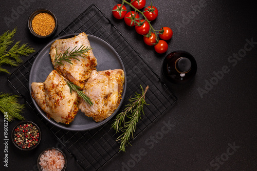 Marinating raw chicken thighs with rosemary and spices