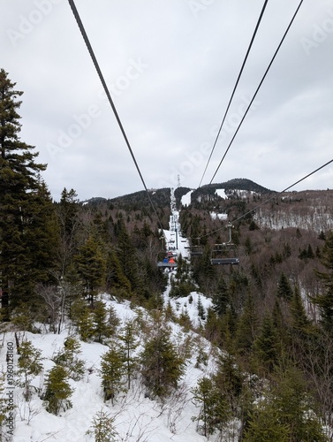 Skiing in winter - chairlift and ski slopes for skiing and snowboarding  between trees on a frosty day with beautiful views in  mountains