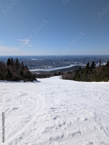 A stunning shot of a ski slope and chairlift near the  town of Mont-Tremblant, Quebec.  Beautiful snow-covered trees, slopes, and forests without people. Laurentian Mountains landscape