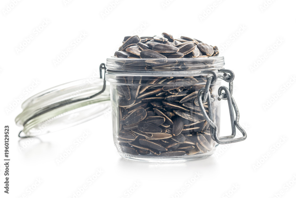 Fototapeta premium Glass Jar Filled With Sunflower Seeds On White Background. Closeup Healthy Snack