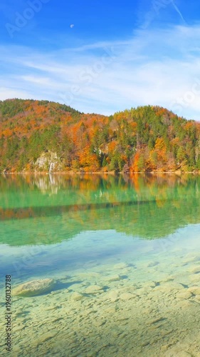 Natural harmony view of alpine lake reflecting autumn forest