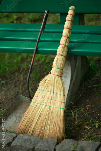 Broom and dustpan near the bench