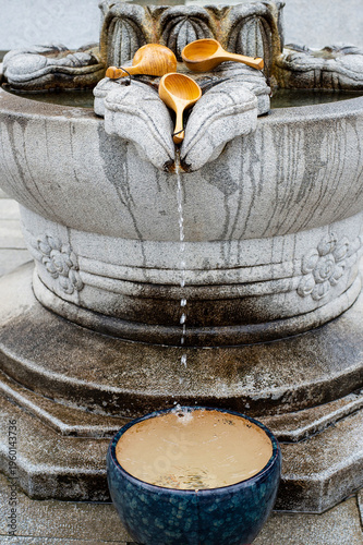 Foto Traditional Korean temple spring water fountain with wooden ladles at a peaceful