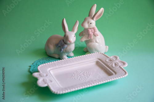 Small white plate plate with white bunny rabbits little statues in porcelain mise en place for food photography