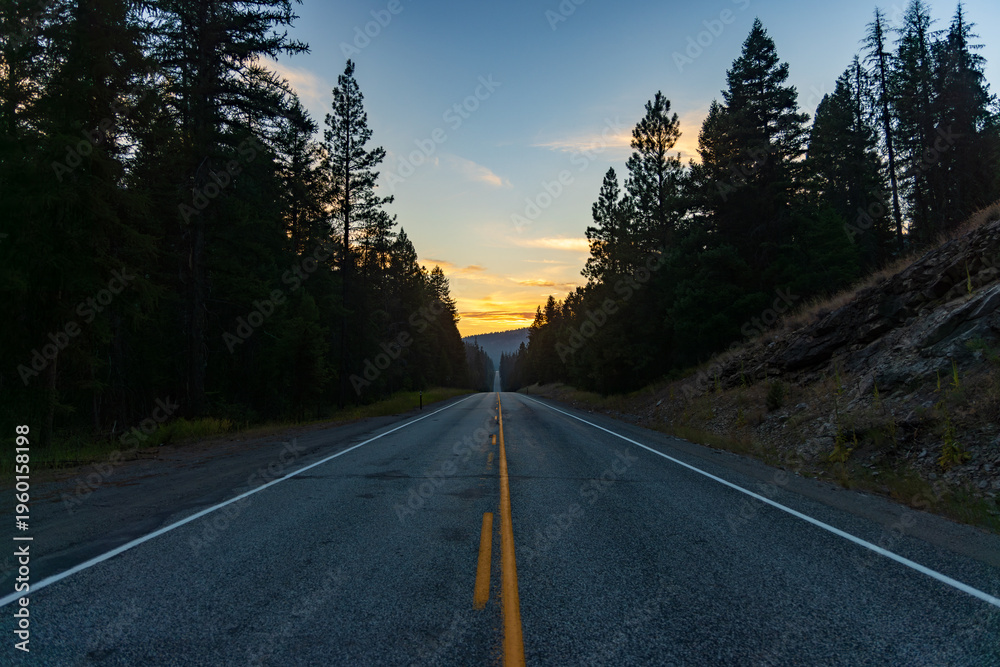 Fototapeta premium lonely road in the mountains facing sunset