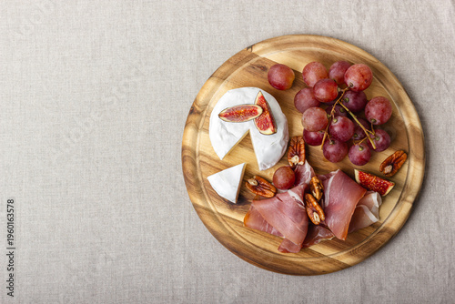Charcuterie board with meat, cheese, grapes, nuts and fresh figs.