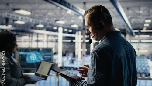 фотографія Data center admin talking in audio headset mic, helping clients resolve website hosting problems