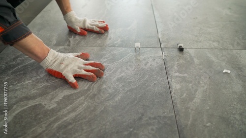 Foto Close up of a construction worker installing large format ceramic tiles on a floor