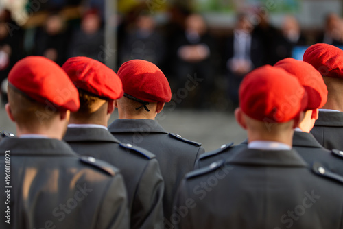 Military: Recruits in grey dress uniform coats and with red wool felt berets at a public oath ceremony
