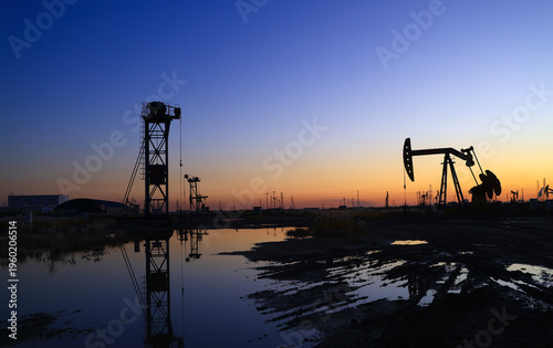 The oil pumping unit is operating in the evening outdoors