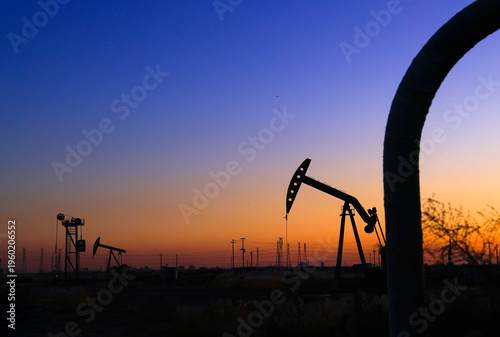 The oil pumping unit is operating in the evening outdoors