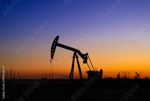 The oil pumping unit is operating in the evening outdoors