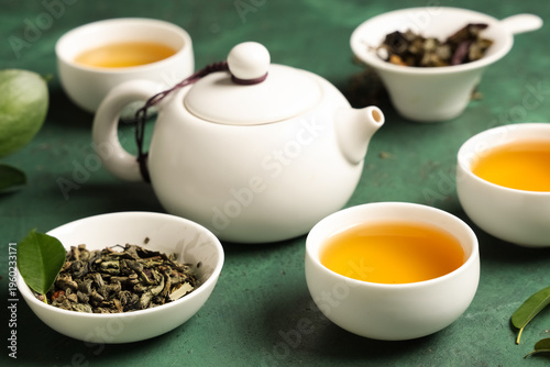 Teapot with cups of tea and...