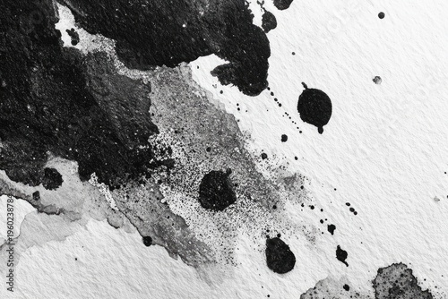 Abstract black ink splatters, drips, and washes on textured white paper
