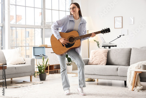 Young girl playing guitar a...