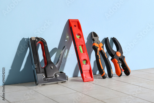 фотографія Spirit level and tools leaned against blue wall