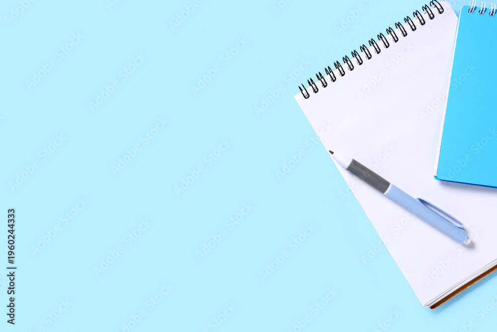 Fototapeta premium Notebooks with pen on blue background