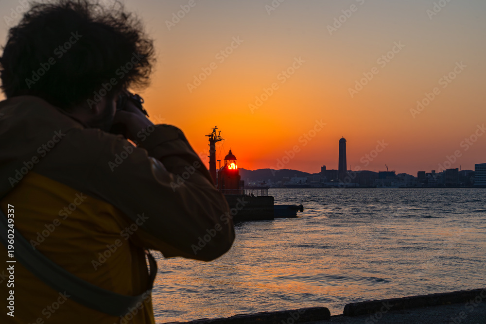 Fototapeta premium 港の夕日を撮影する旅人20260321