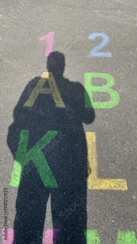men’s shadows on a playground with the alphabet written on the asphalt. The scene symbolizes winer and victory or first place. Vertical video