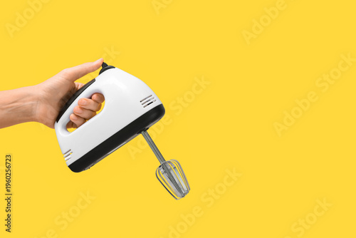Woman holding electric mixe...