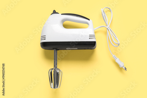 Electric mixer on yellow ba...