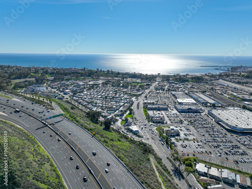 Aerial view over San Juan Capistrano, California, featuring the historic mission, library, sports courts, and an Amtrak train pulling into the downtown station. High quality 4k footage