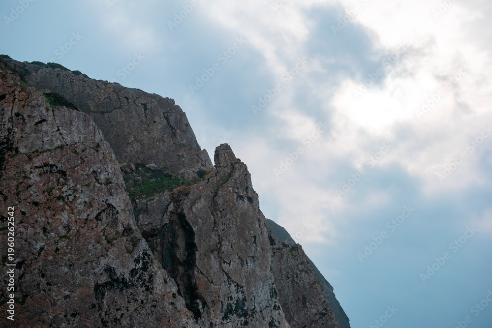 Fototapeta premium Rugged Cliff Face Under Cloudy Sky