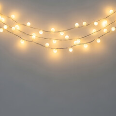 Three strands of glowing white fairy lights on a grey background