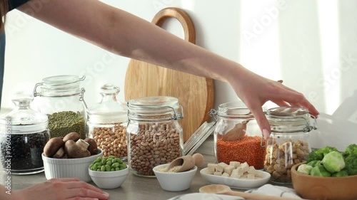 Woman with vegan products rich in protein at table indoors, closeup