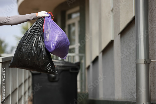 Female hand with garbage ba...