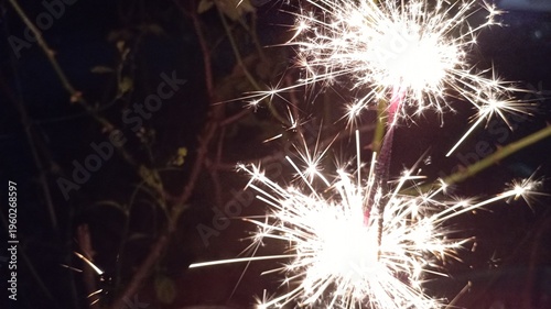 Sparkler fireworks glowing at night serve as decorative celebration elements and entertainment tools creating a warm festive and romantic atmosphere
