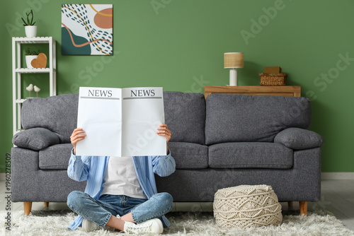 Young woman reading blank n...