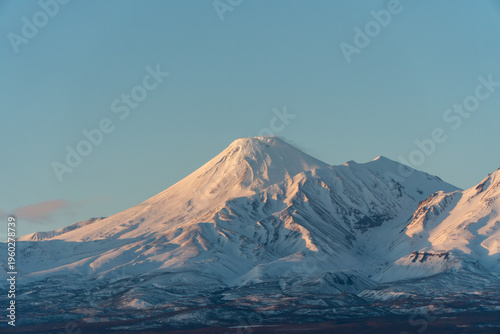Fotografie Snow covered volcanoes of Kamchatka peninsula at sunset dramatic winter mountain