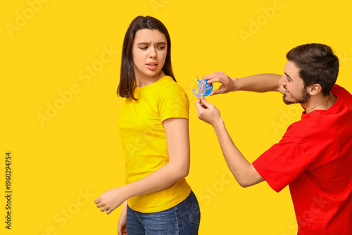 Young man sticking paper on...