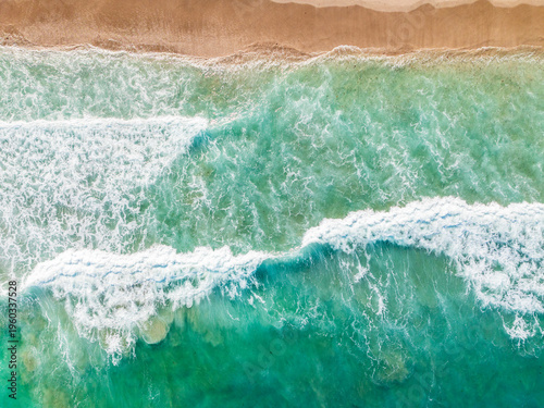 Tablou pe pânză aerial drone view of waves crashing on beach