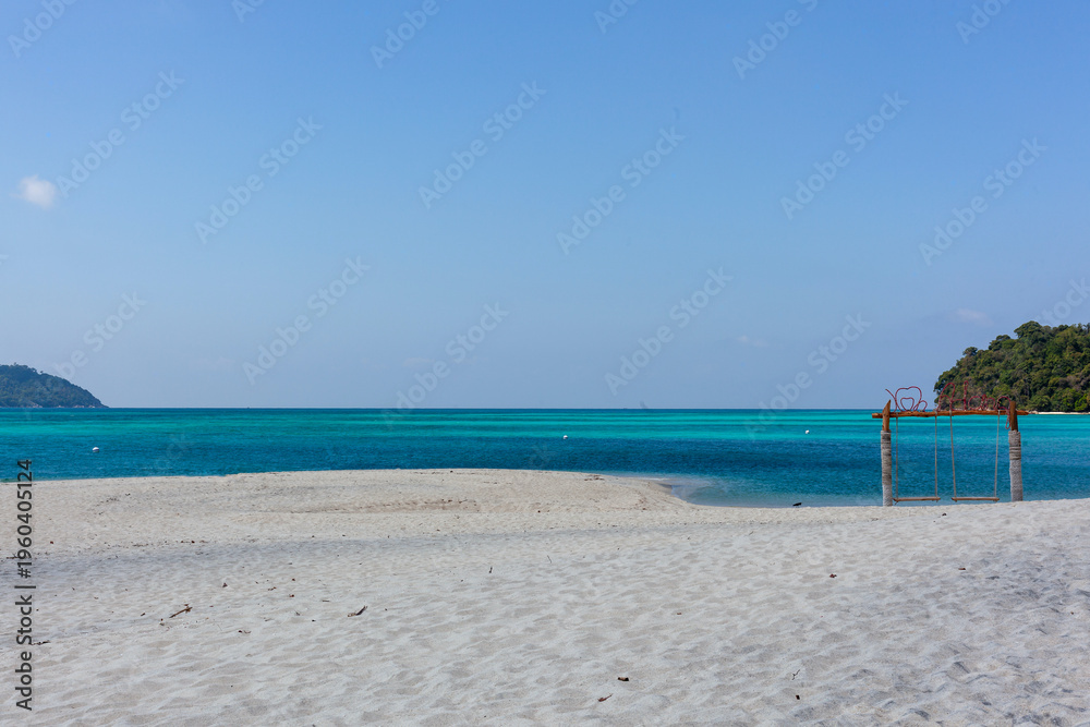 Obraz premium Tropical beach at Koh Adang with clear blue water. White sand shoreline in Tarutao National Park, Thailand. Secluded island setting with turquoise sea.