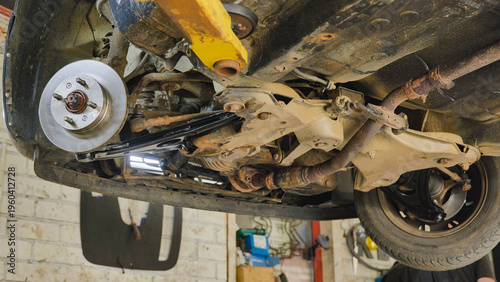 фотографія Car undercarriage lifted for inspection and brake replacement showing suspension