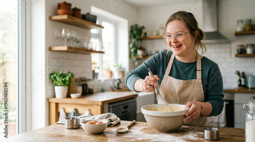 A smiling woman with Down syndrome in an apron mixing ingredients in a bowl in a bright kitchen, home baking activity, disability inclusion, adult hobby.