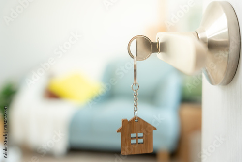 Moving house, relocation. The key was inserted into the door of the new house, inside the room was a cardboard box containing personal belongings and furniture. move in the apartment or condominium