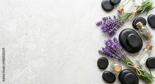 Black smooth spa stones with fresh lavender and oil perfect for natural wellness massage concept and relaxing aromatherapy treatment