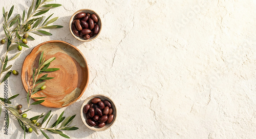 Fresh olive branches and bowls on textured beige surface perfect for natural organic food concept and healthy Mediterranean diet promotion