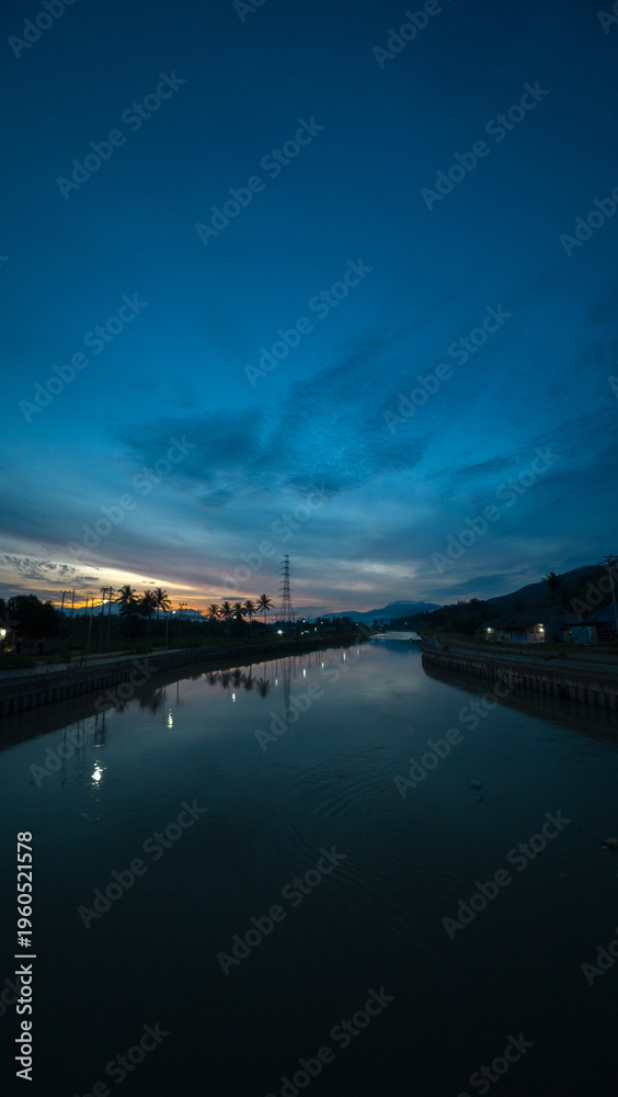 Fototapeta premium River Landscape at Dusk with Dramatic Sky