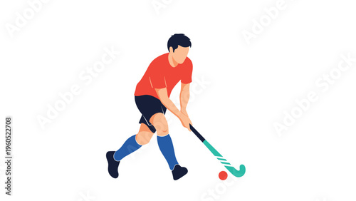 Active male athlete playing field hockey while dressed in a red jersey and blue socks, swinging his stick at a ball.