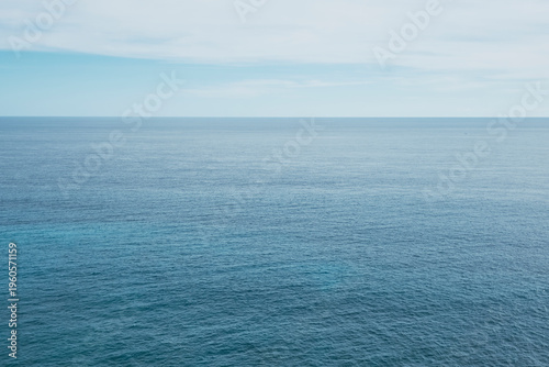 Ocean appears endless under a bright sky with clear blue water