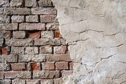 old bred rick wall with rough surface and a part of a broken cement wall, space for text, texture and background