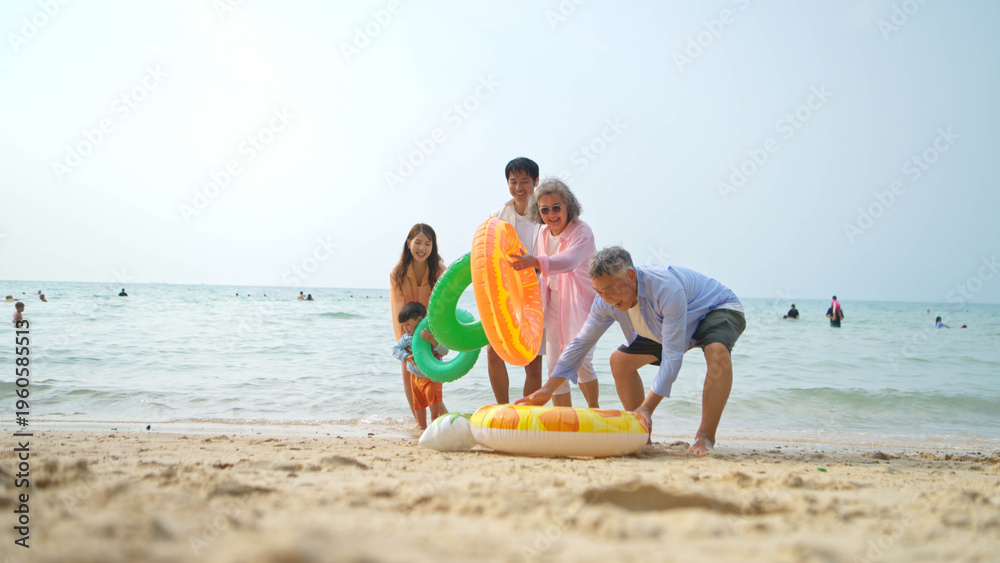 Obraz premium Extended family standing and playing together with inflatable rings
